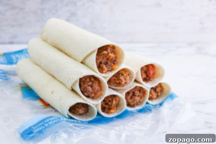 Crispy Air Fryer Flautas 7 Stacked beef and cheese taquitos, perfect for the air fryer, are nestled in clear plastic packaging, ready for cooking or storage.