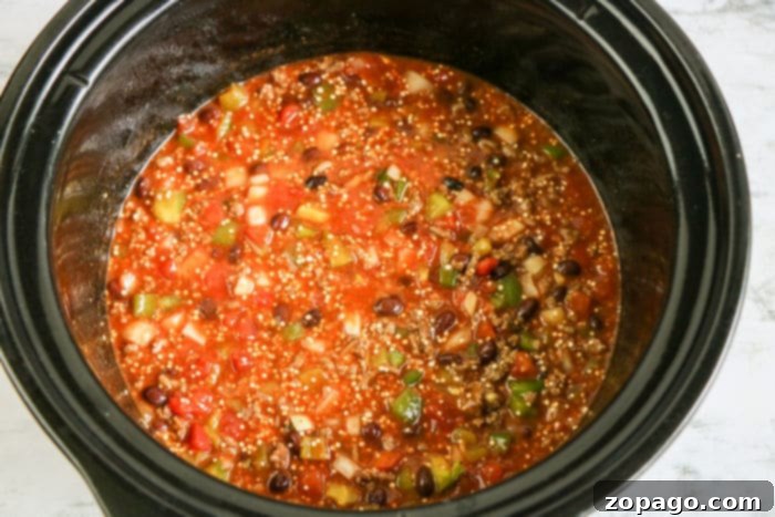 Easy Slow Cooker Enchilada Casserole 5 Close-up of a bubbling Crockpot enchilada casserole, showcasing the melted cheese and rich, saucy filling.