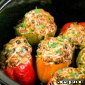 Crockpot stuffed bell peppers bursting with colorful cheese and herbs, slowly cooked to perfection.