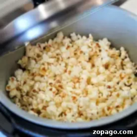 A pot filled with freshly popped popcorn inside an open Ninja Foodi pressure cooker.