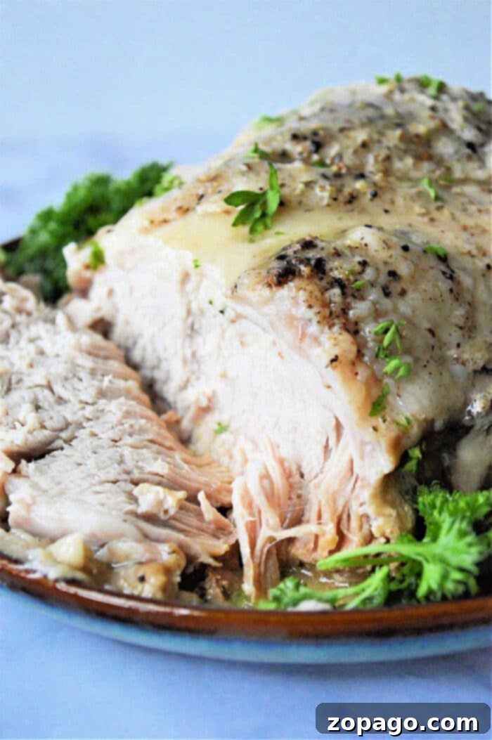 No Thaw Instant Pot Pork Roast 7 Frozen pork roast cooked in an Instant Pot with herbs, sliced and served on a plate garnished with fresh parsley.