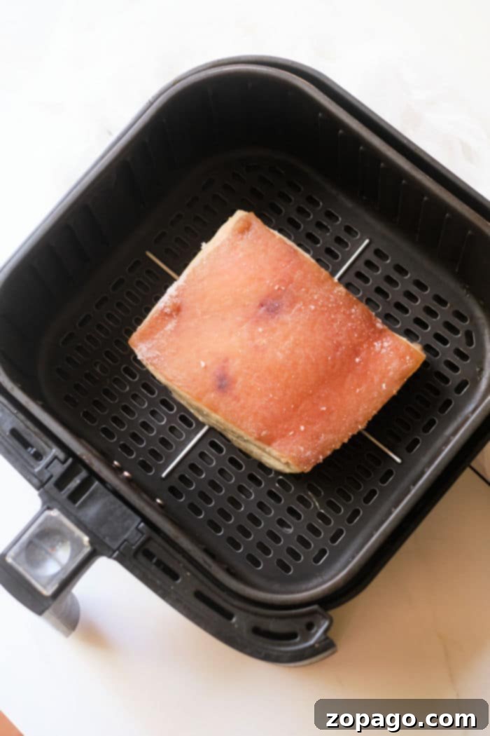 Crispy Instant Pot Pork Belly Bites 6 A slice of pork belly being toasted inside an air fryer basket pairs perfectly with the savory flavors of instant pot pork belly.