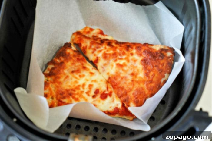 Air Fryer Pizza Reheat: Crispy Perfection 7 reheat pizza in air fryer - Two perfectly reheated pizza slices, one with pepperoni and one plain cheese, being held up to show their crispy crust and melted cheese.