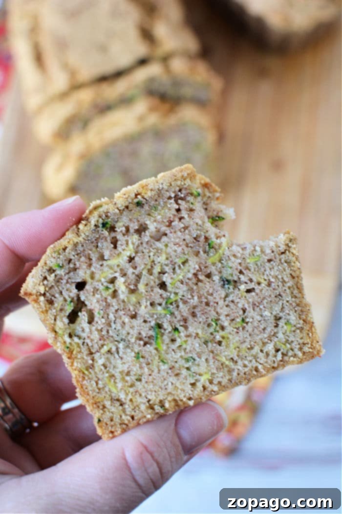 Crispy Air Fryer Zucchini Loaf 8 A close-up of a slice of air fryer zucchini bread, revealing its moist, tender interior with flecks of zucchini.