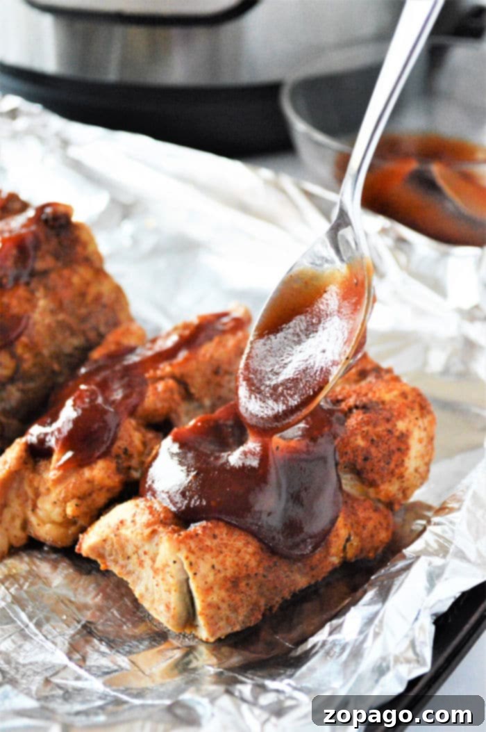 Instant Pot Country Style Pork Ribs 6 Country Pork Ribs - Plated with a generous amount of BBQ sauce and garnished.