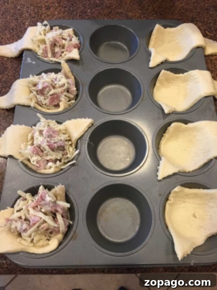 Reinvent Your Leftover Ham 3 Muffin tray with unbaked crescent rolls filled with a delightful cheese and leftover ham mixture.