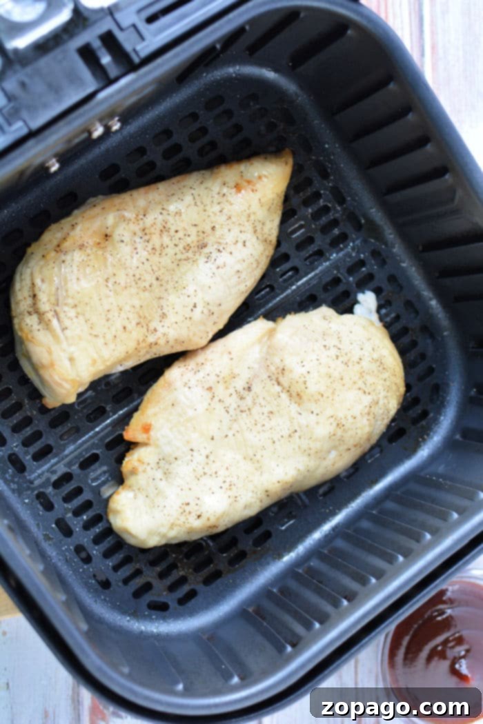 Juicy Air Fryer BBQ Chicken Breast 5 Close-up of a cooked air fryer BBQ chicken breast, covered in a rich, glossy barbecue sauce, ready to be enjoyed.