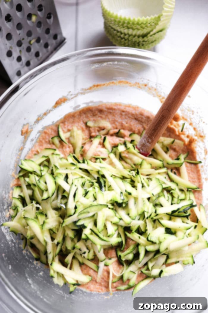 Wholesome Zucchini Applesauce Muffins 5 Freshly baked Zucchini Applesauce Muffins cooling on a wire rack, with a view of their golden tops and tender texture.