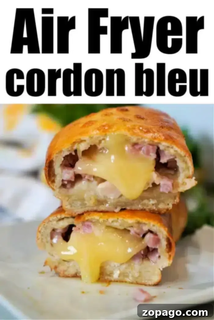 Crispy Air Fryer Chicken Cordon Bleu 10 A close-up of an air fryer chicken cordon bleu, sliced in half to reveal melted cheese and pieces of ham nestled within a golden-brown crust. The text above reads "Air Fryer Chicken Cordon Bleu." The dish is elegantly presented on a white plate.