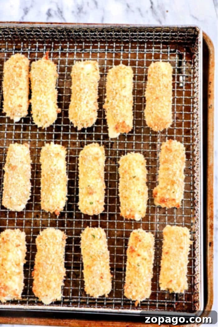 Crispy Air Fryer Mozzarella Sticks 2 Homemade air fryer mozzarella sticks arranged on a plate