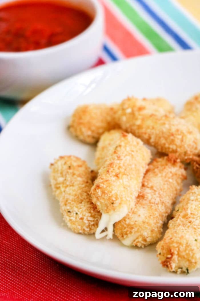 Crispy Air Fryer Mozzarella Sticks 10 Homemade air fryer mozzarella sticks presented beautifully on a plate