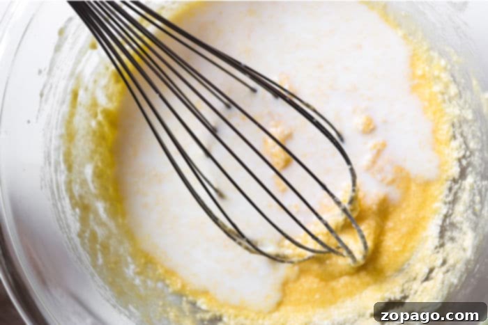 A mixing bowl with muffin batter being stirred, indicating the baking process is underway.