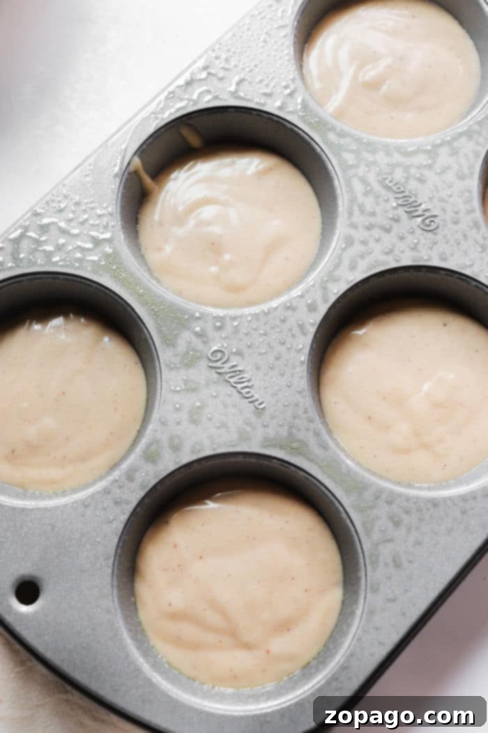 Freshly baked Donut Muffins on a cooling rack, ready for coating.
