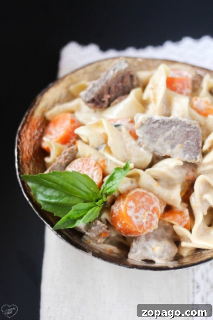 Crockpot beef stroganoff that only requires 5 ingredients and cooks all day in the crockpot. The best way to make tender beef with a creamy sauce. #crockpot #slowcooker #beefstroganoff #beef #stew A vibrant close-up of beef stroganoff with tender beef and a creamy sauce, ready to be enjoyed.