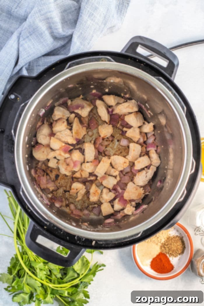 Instant Pot Olive Garden Inspired Chicken Pasta 5 Instant Pot sauteed chicken and onions browning in the inner pot.
