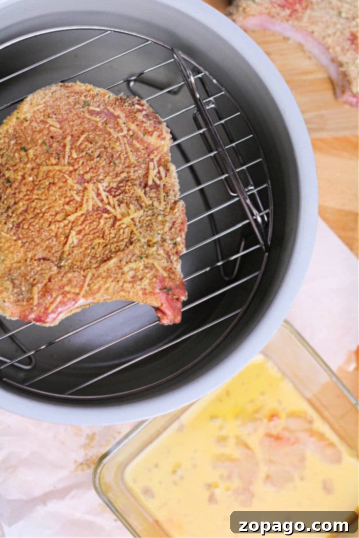 Crispy Air Fryer Pork Chops 7 Cooked breaded pork chops served hot from the Ninja Foodi, showcasing a golden crust and tender interior.