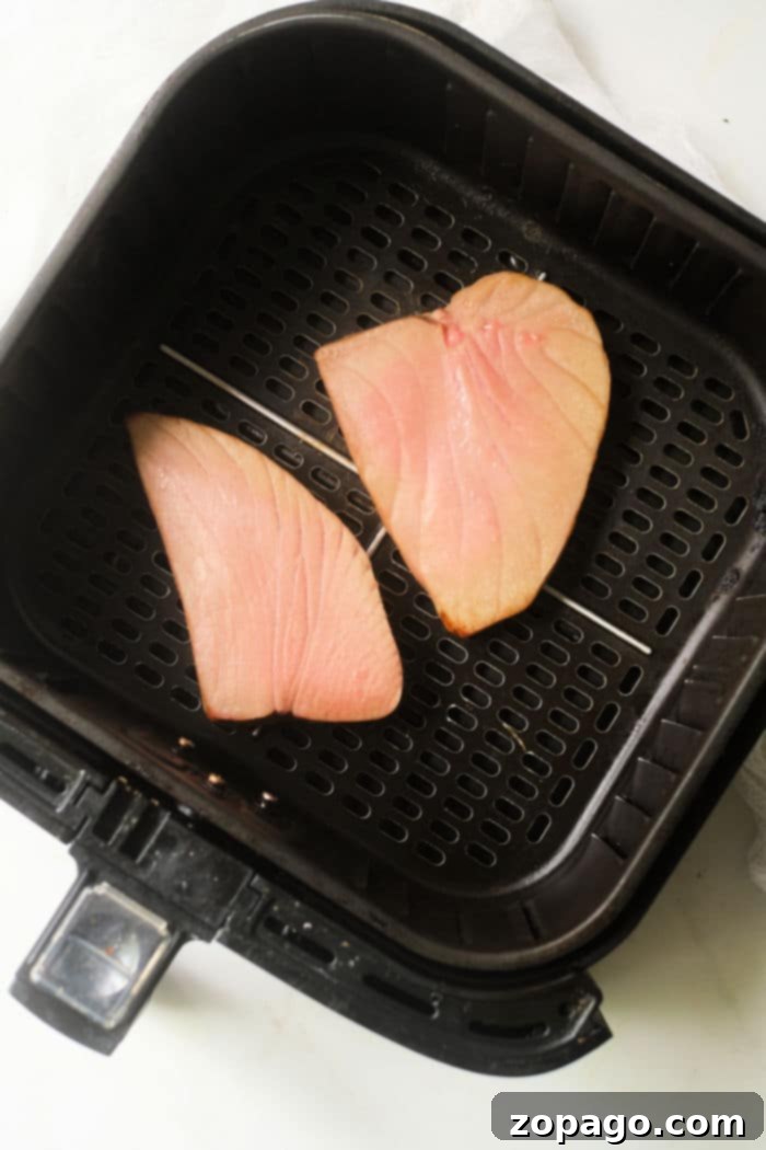 Air Fryer Tuna Steaks 5 Slices of perfectly seared tuna steak in an air fryer, ready to be served.