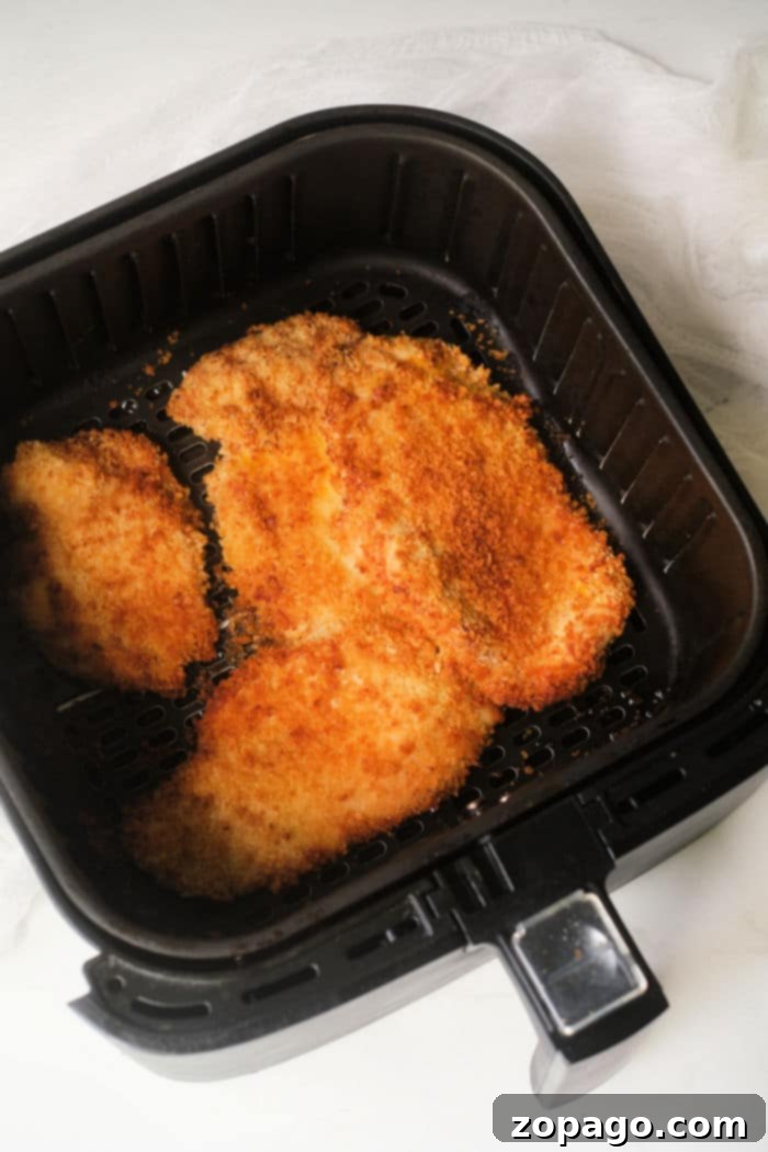 Air Fryer Chicken Katsu 9 Sliced Chicken Katsu in an air fryer basket, ready to be served.