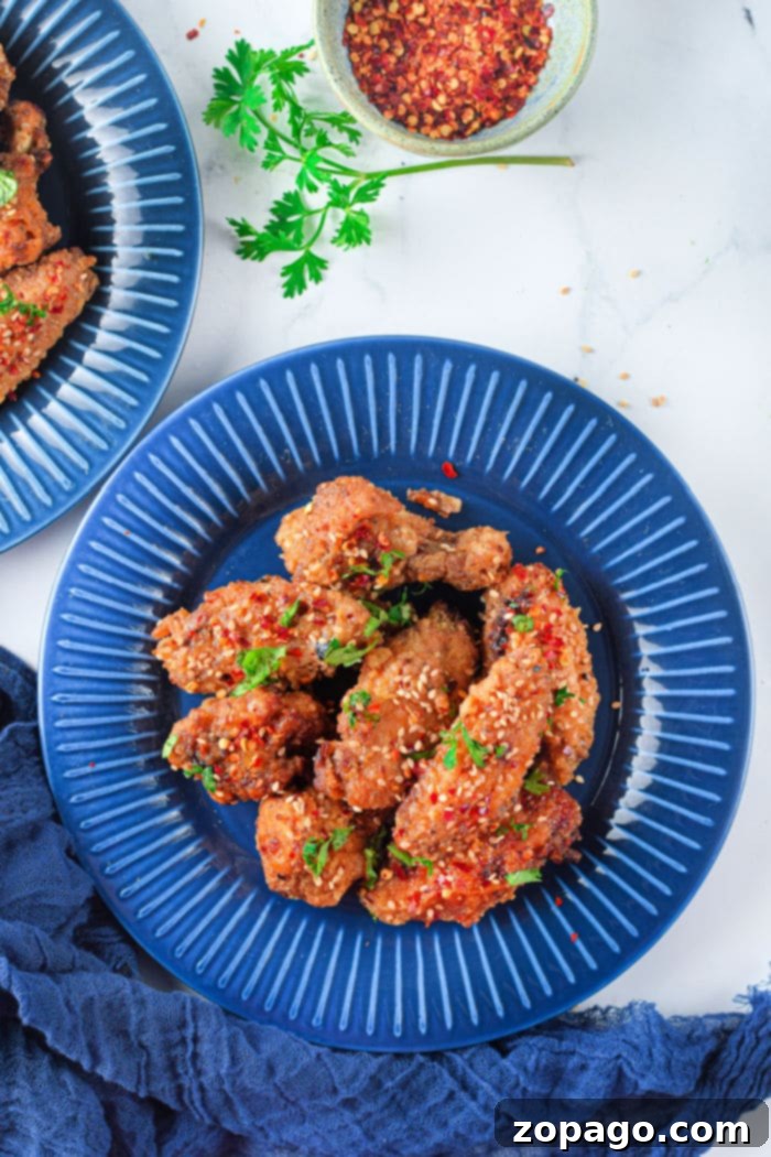 Dynamite Chicken 11 Close-up of deliciously glazed air fryer firecracker chicken wings on a plate.