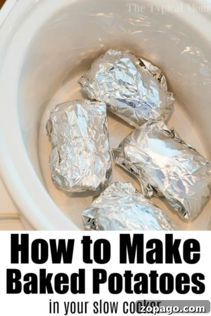 Easy Slow Cooker Baked Potatoes 7 Two crockpot baked potatoes, one whole and one cut open with toppings, on a white plate with a fork.