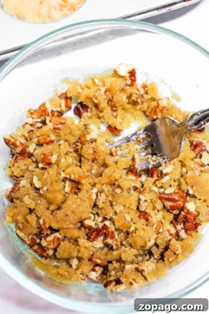 Spiced Sweet Potato Muffins 5 Bowl of homemade streusel topping with pecans and a fork, ready to be sprinkled over muffins.