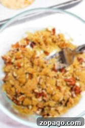 Spiced Sweet Potato Muffins 8 Bowl of crumbly streusel topping with pecans and a fork, perfect for your next sweet potato muffin recipe.