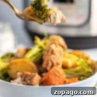 Speedy Instant Pot Chicken and Garden Vegetables 8 A fork holding broccoli and potato over a bowl of vibrant vegetables and tender chicken, with an Instant Pot subtly positioned in the background.