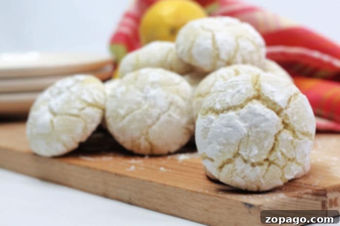 Zesty Lemon Crinkle Cookies 5 A close-up shot of several lemon crinkle cookies, perfectly crinkled and powdered, arranged on a cooling rack.