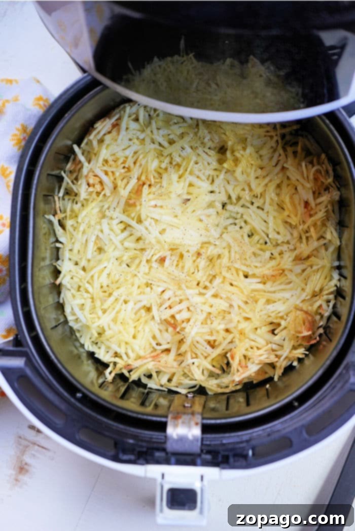 Perfectly Crispy Air Fryer Frozen Hash Browns 5 A close-up of crispy shredded potatoes, golden brown and ready to eat, served in a bowl.