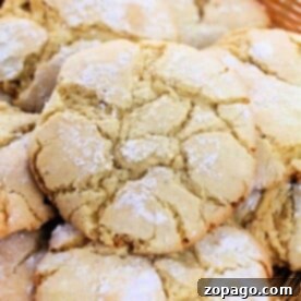 Close-up of a basket filled with round, cracked cookies made from a simple 3 ingredient cake mix, dusted generously with powdered sugar.