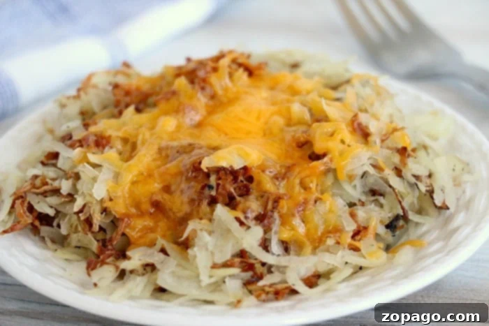 Slow Cooker Cheesy Hash Browns 8 A close-up of crispy, golden cheesy hashbrowns, generously topped with melted cheese and fresh green onions.