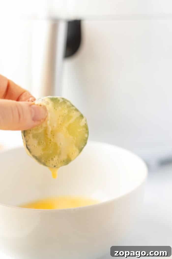 Air Fryer Cucumber Crisps 5 Preparation stages of cucumber chips: sliced cucumbers and breading ingredients.
