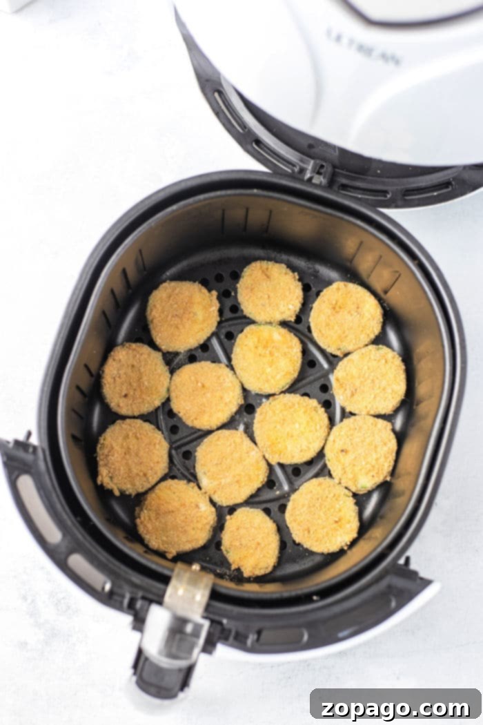 Air Fryer Cucumber Crisps 6 Cucumber slices coated in breading, ready for air frying.