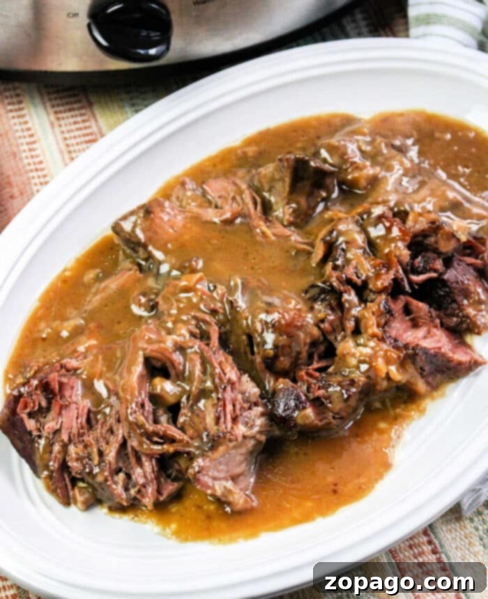 Fall-Apart Tender Slow Cooker Roast Beef and Savory Gravy 11 Crockpot roast beef and gravy with onion soup mix, ready to serve.