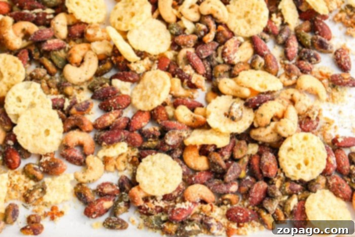 Cheesy Crunch Mix 7 A close-up of a bowl filled with a homemade Cheese It Snack Mix, featuring a generous blend of savory crackers and seasoned nuts.