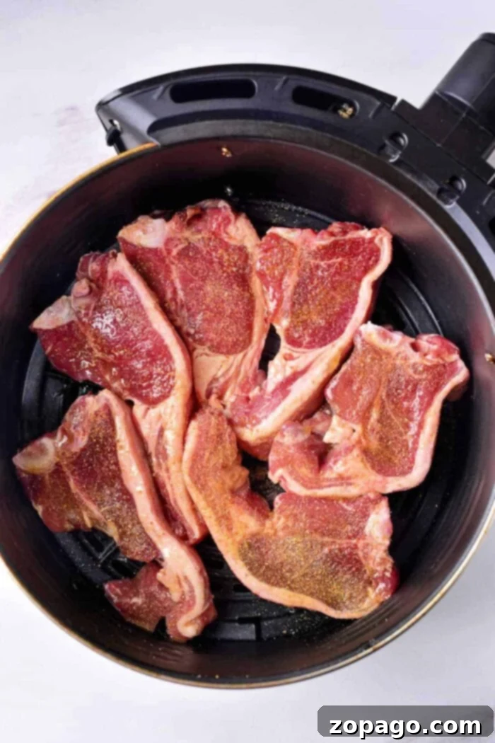 Perfect Air Fryer Lamb Chops 5 Ninja Foodi lamb chops, perfectly cooked and ready to serve, presented on a plate with fresh herbs