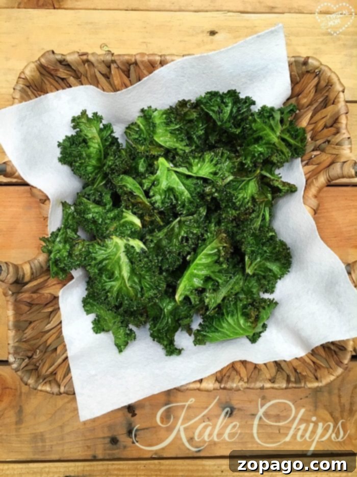 Easy kale chips recipe for those of you, like me, who weren't believers. They really are good and tasty, even my kids liked them! #kale #kalechips Easy kale chip recipe, showing a pile of crunchy, seasoned kale chips on a plate, a perfect healthy snack option.