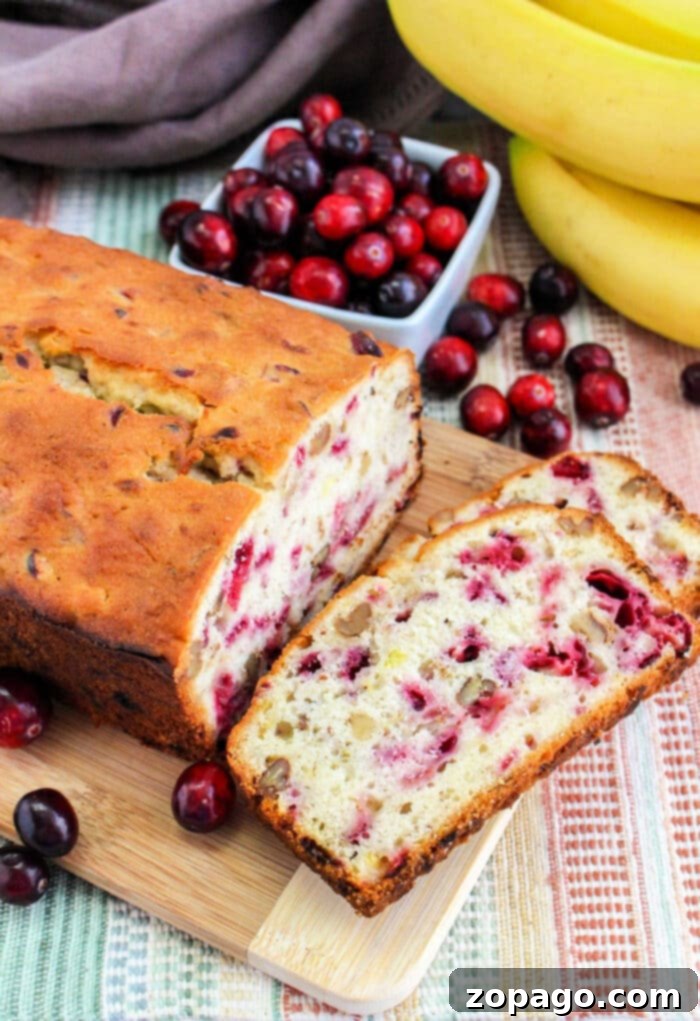 Golden Cranberry Banana Loaf 2 Delicious Cranberry Banana Bread loaf, perfectly sliced and ready to serve, a top-rated recipe for holiday baking.