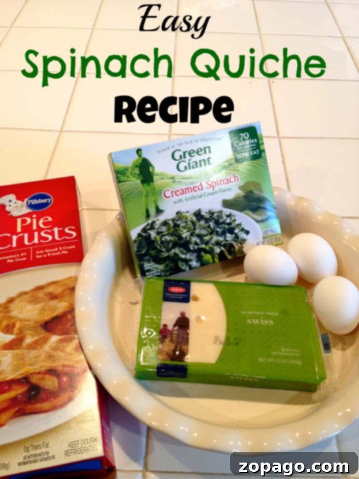 Ingredients for an easy mini quiche recipe: pie crust, creamed spinach, Swiss cheese, and eggs neatly arranged on a kitchen counter.