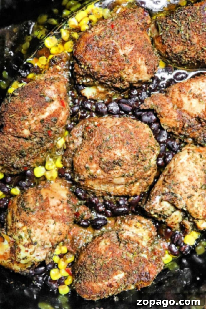 Effortless Slow Cooker Jerk Chicken 2 Tender Crockpot Jerk Chicken Thighs cooked with corn and black beans, ready to be served over rice.