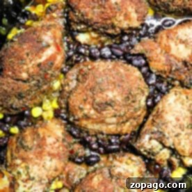 Effortless Slow Cooker Jerk Chicken 5 Seasoned chicken thighs with black beans and corn in a crockpot, richly spiced to create a jerk chicken masterpiece cooked to perfection.