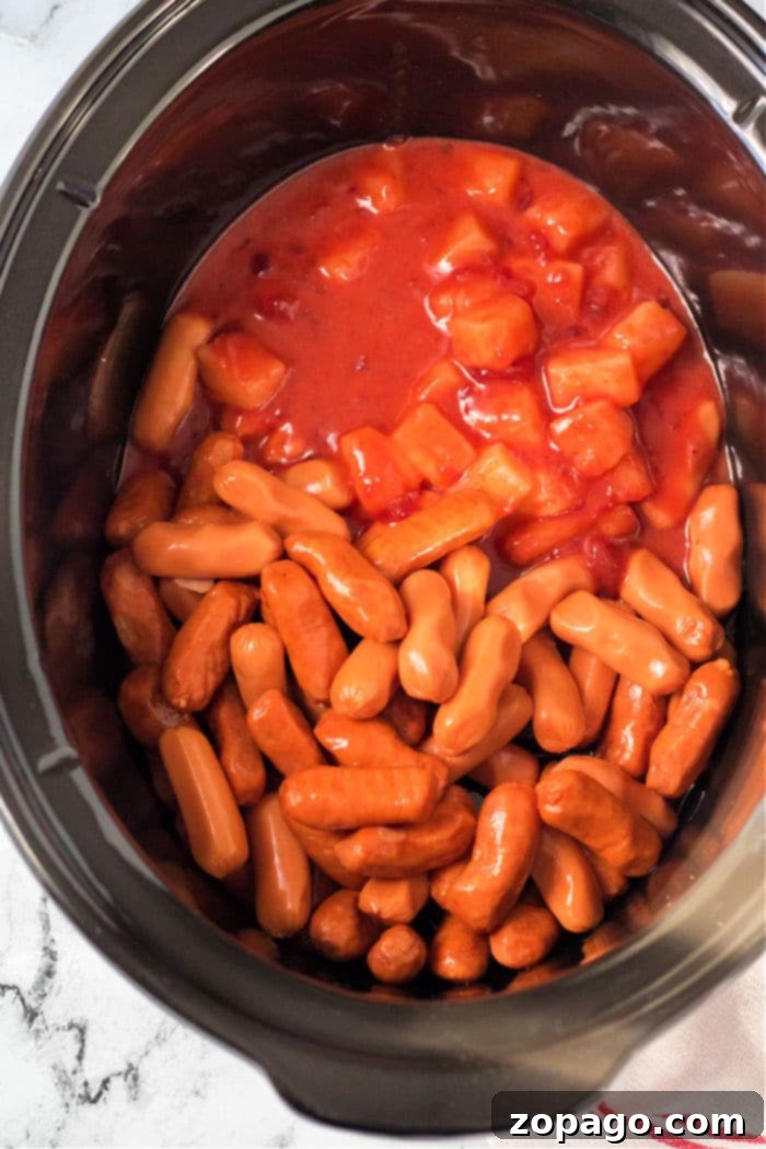 Sweet and Sticky Slow Cooker Sausages 5 slow cooker Smokies Recipe in a vibrant red crockpot