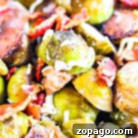 Slow Cooker Brussels Sprouts 6 Close-up of roasted Brussels sprouts with crispy bacon bits and melted cheese, slow-cooked to perfection in a crockpot.