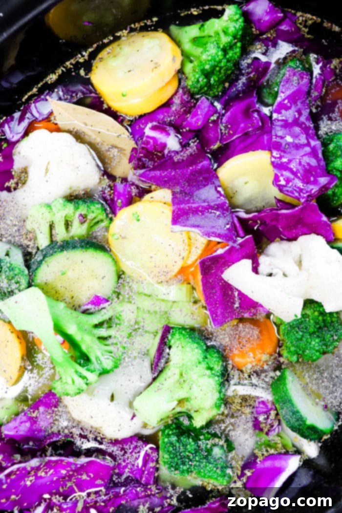 Vibrant Slow Cooker Purple Cabbage Soup 7 A steaming bowl of colorful cabbage soup, featuring both red and green cabbage, carrots, and other vegetables, garnished with fresh herbs.