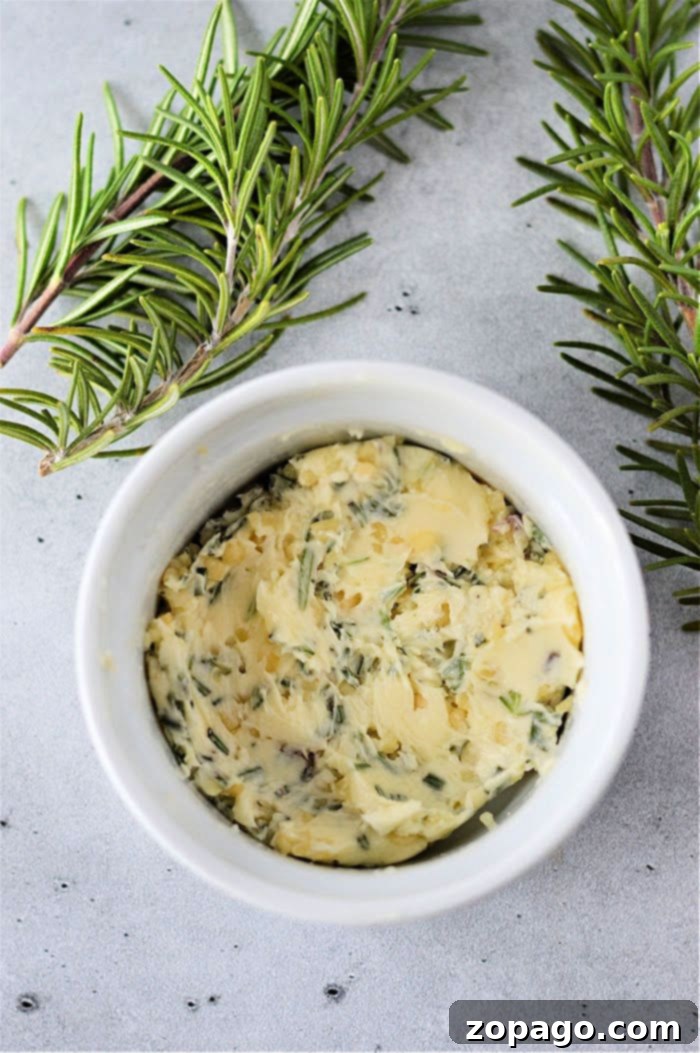 Perfectly Cooked Steak, From Frozen 4 Herb-infused butter in a white ramekin, garnished with fresh rosemary sprigs on a light gray surface, is the perfect complement when you learn how to cook frozen steak to perfection.