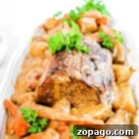A plate of tender sirloin tip roast, slow-cooked to perfection with carrots, potatoes, and a parsley garnish, all generously covered in savory gravy.