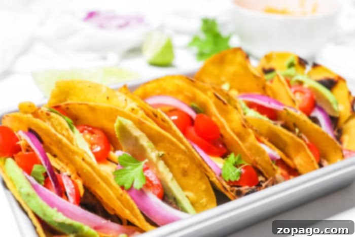 Effortless Slow Cooker Taco Meat 10 Close-up of freshly prepared crockpot tacos with a variety of toppings.
