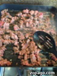 Effortless Slow Cooker Taco Meat 4 Ground beef and onions sizzling in a grill pan, ready for the slow cooker.