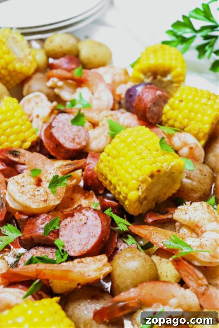 Easy Slow Cooker Shrimp Boil 2 Delicious Crockpot Shrimp Boil with shrimp, sausage, corn, and potatoes in a vibrant red seasoning
