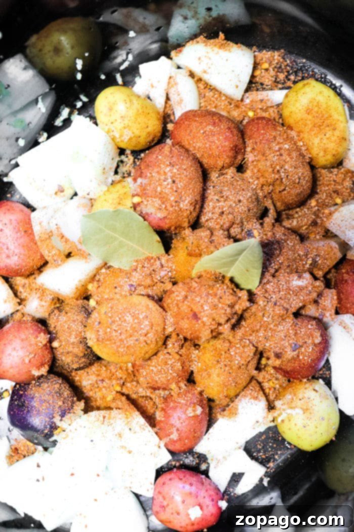 Easy Slow Cooker Shrimp Boil 8 A serving of Crockpot Shrimp Boil with large shrimp, corn, and potatoes, ready to be eaten.